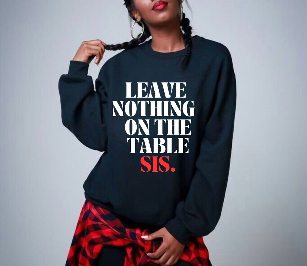 Model wearing the SheeApparel® Leave Nothing on the Table, Sis™ black crewneck sweatshirt featuring bold white and red affirmation text