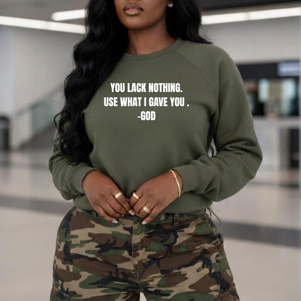 Person wearing a green sweatshirt with motivational quote and camouflage pants in an indoor setting