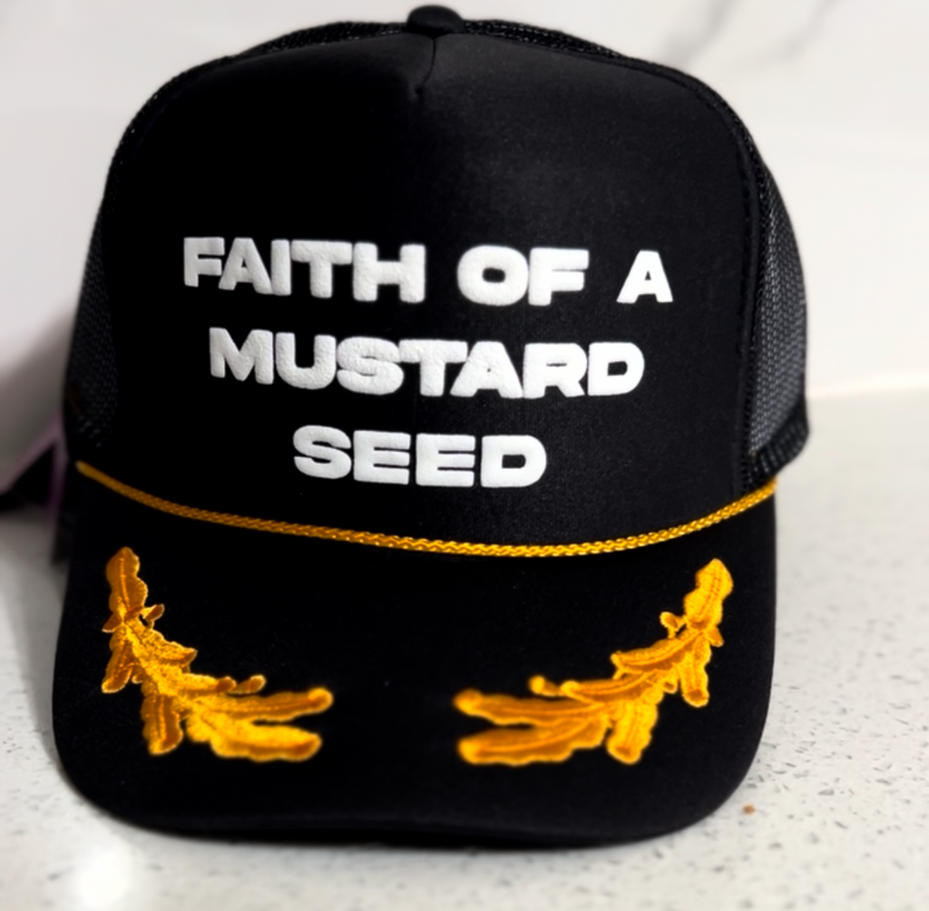 Black cap with 'Faith of a Mustard Seed' text and mustard seed designs on a white background